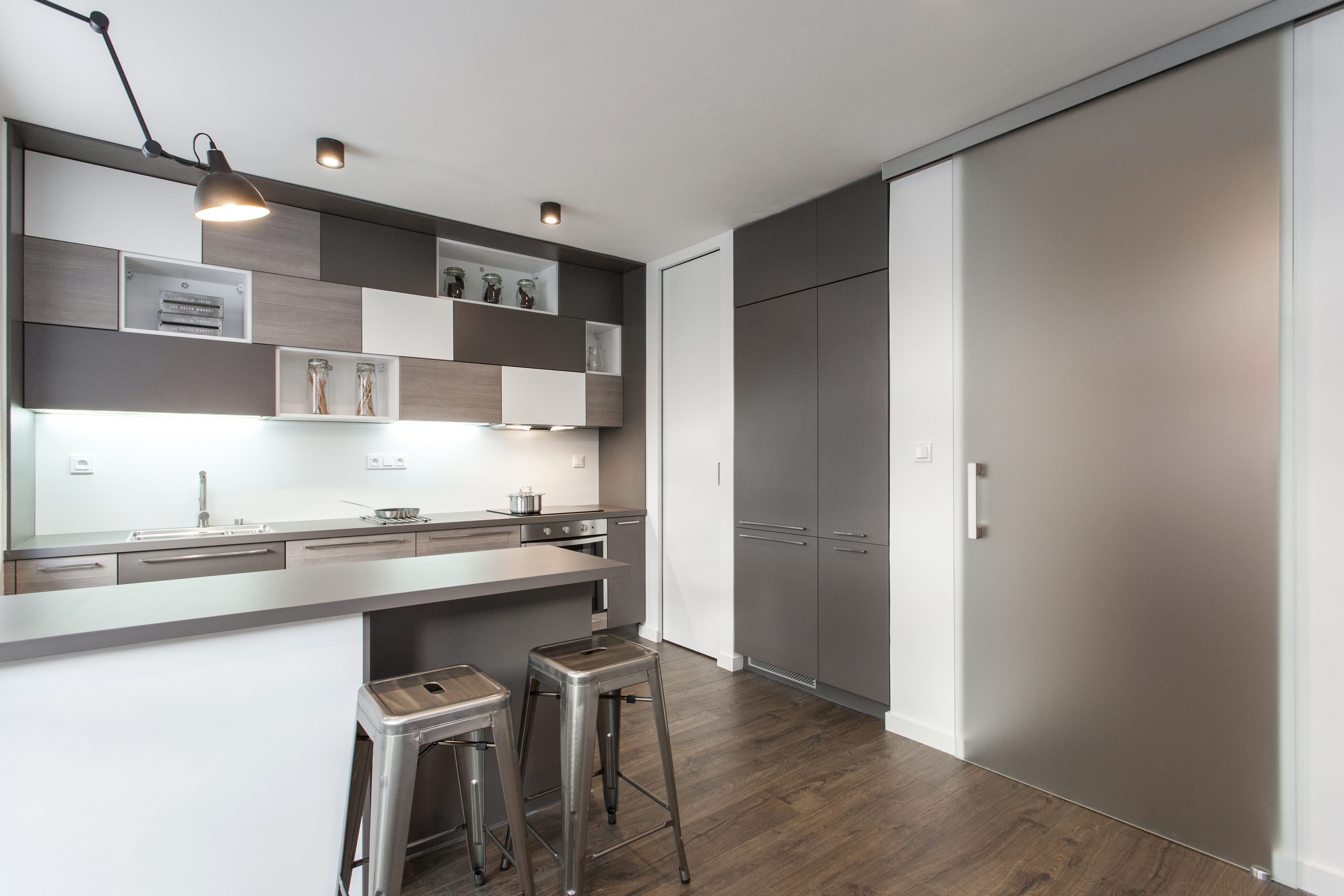 Interiérové dveře posuvné na zeď celoskleněné v minimalistické garnýži v kuchyňském prostoru 