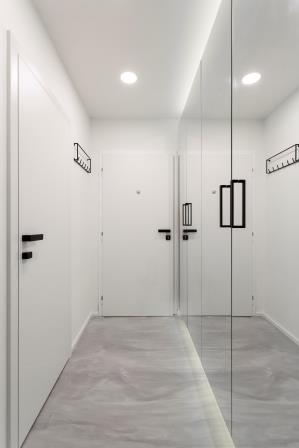 Moderní bílé bezfalcové dveře s černou klikou