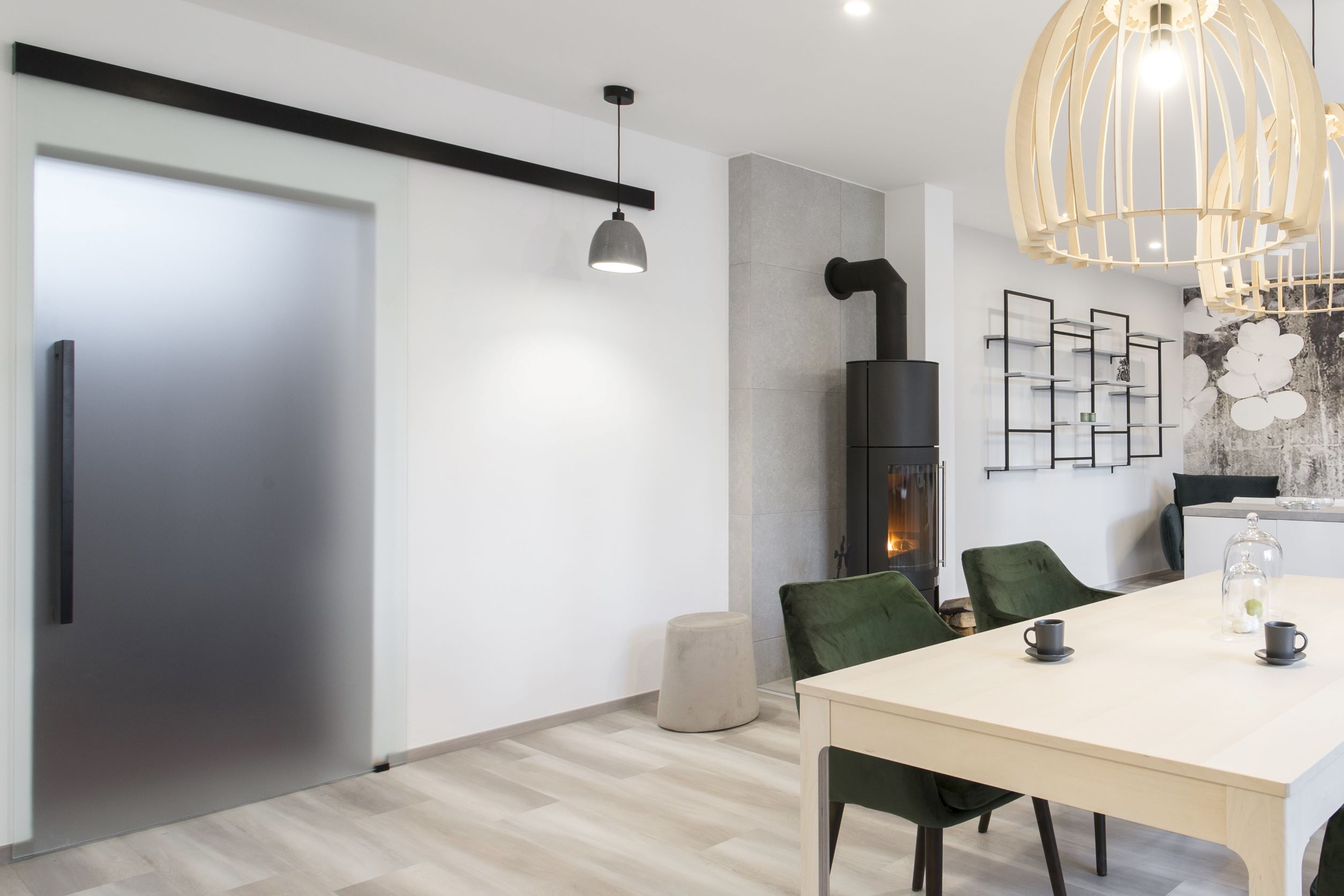 Interiérové celoskleněné dveře posuvné v prostoru s minimalistickou černou garnýží 
